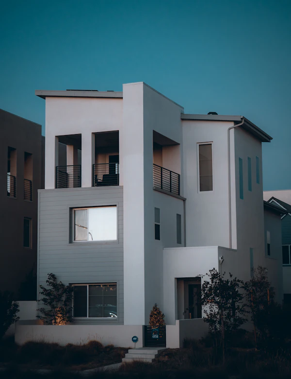 Akşam saatinde beyaz cepheli üç katlı modern konut