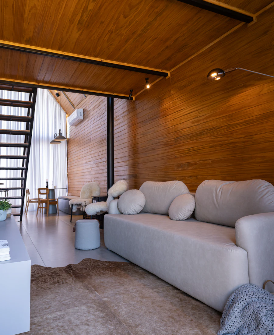 Ahşap tavan ve duvar kaplamalı, beyaz koltuklu modern salon